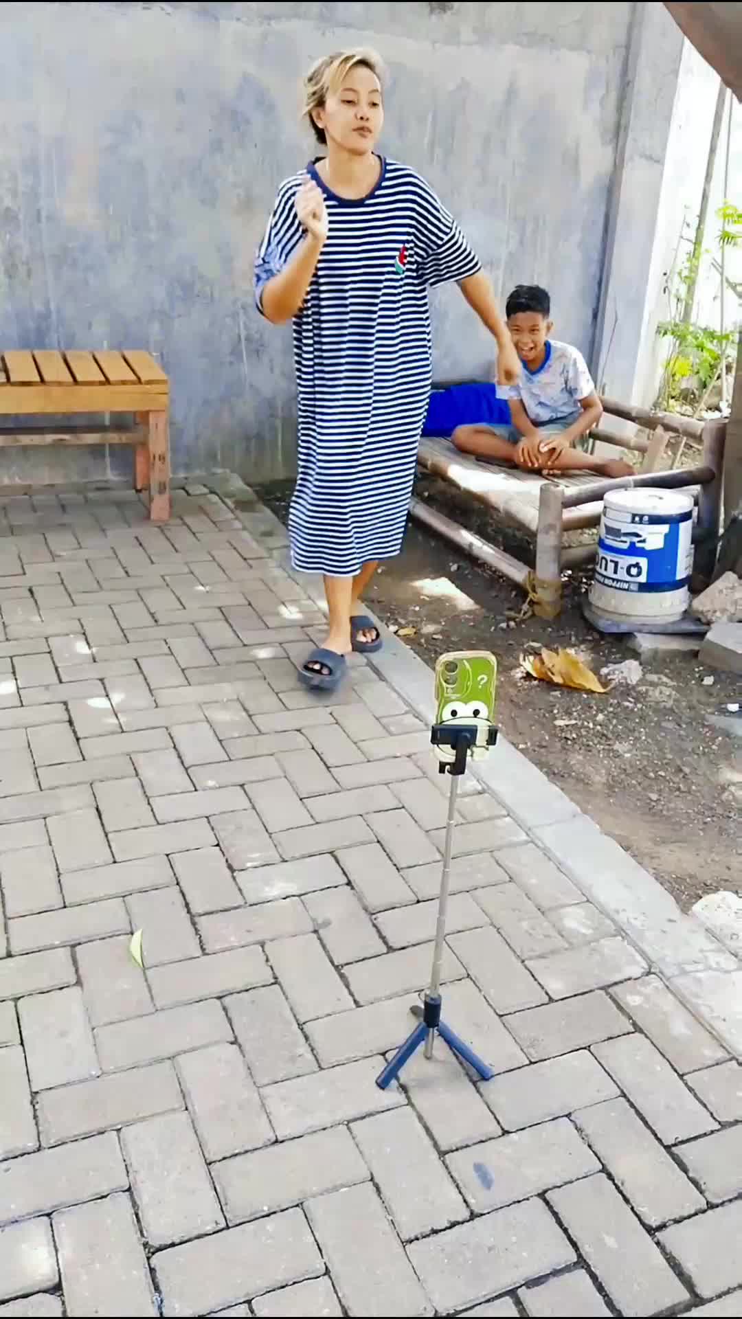 di balik emak bikin vidio ada anak yang cekikikan. 